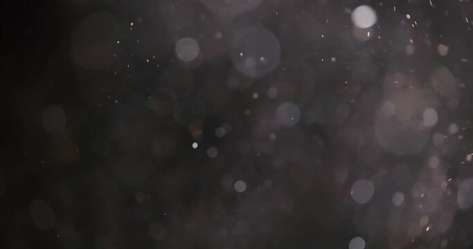 Floating abstract particle bokeh on dark background