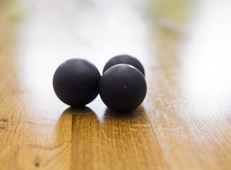 Black squash balls in squash court