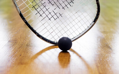 Black squash ball and tennis racket