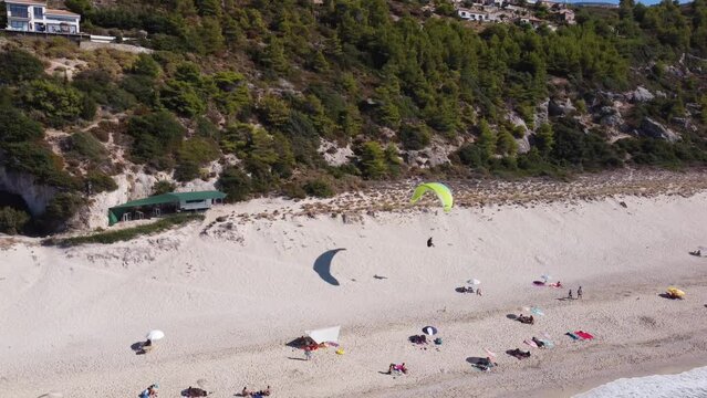 Aerial view of para glider landing on Milos beach in summer season on Lefkada island.