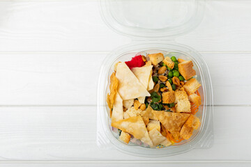 Poke from salmon, funchose, vegetables and pita crispy on a white wooden background.Healthy healthy food.Hawaiian food. View from above. Place to copy.