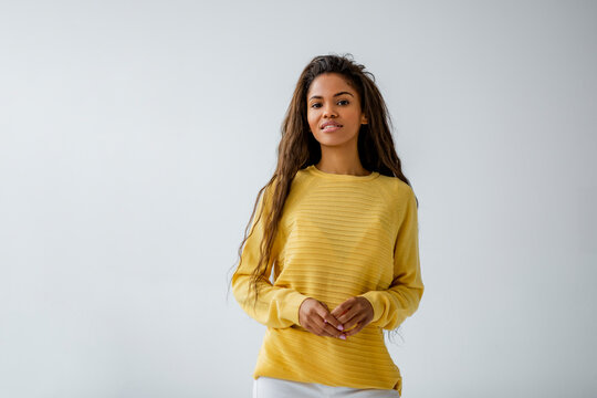 Beautiful Black Woman With Long Curly Hair Posing For Camera In Yellow Sweater  