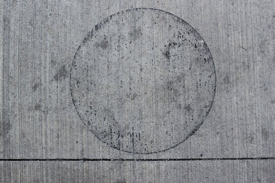 Black Circle Inscribed Into The Concrete Pavement.