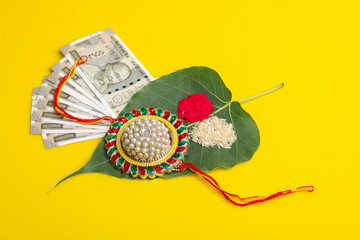 Indian festival: Raksha Bandhan. A traditional Indian wrist band with kumkum,rise and indian currency.