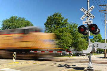 Freight train in motion speeding at crossing gate