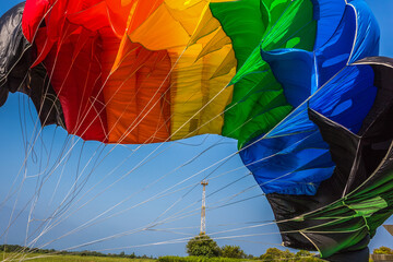 Abлhazia Sukhum Babushara 09.14.2017  Canopy of colorful parachute in blue sky. A background with an abstract view of a colorful parachute. Parachute jumps. Active life style. - obrazy, fototapety, plakaty