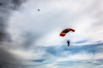 Russia Moscow region Vatulino. 05.16.2018 Colorful parachut on the dramatic sky with stormy clouds. Parachute jumps. Active life style.