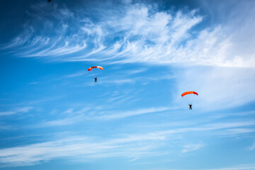 Russia Moscow region Vatulino. 08.10.2018 Two colorful parachutes on blue cloudy sky. Parachute jumps. Active life style.