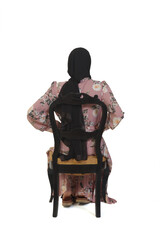 rear view of full portrait of a woman with burka sitting on chair on white background