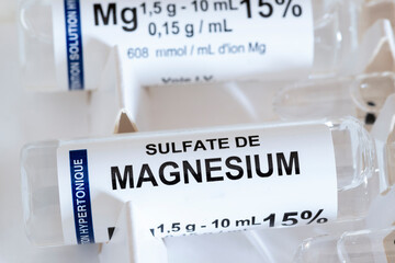 Close-up of Magnesium Sulfate vial for injections or infusion against red background. Ideal for medical concept blogs or articles - obrazy, fototapety, plakaty
