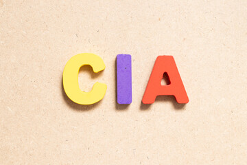 Color alphabet letter in word CIA (abbreviation of certified internal auditor) on wood background - obrazy, fototapety, plakaty