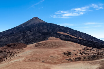 Fototapeta na wymiar Hiking trail over volcanic desert terrain leading to summit of volcano Pico del Teide from Pico Viejo, Mount Teide National Park, Tenerife, Canary Islands, Spain, Europe. Solidified lava, ash, pumice