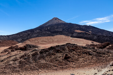 Hiking trail over volcanic desert terrain leading to summit of volcano Pico del Teide from Pico...