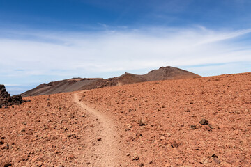Hiking trail over volcanic desert terrain leading to summit of volcano Pico del Teide from Pico...