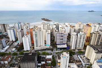 Fototapeta premium Cidade Guarujá vista de cima. Praia das Astúrias com seus prédios, mar e natureza. 