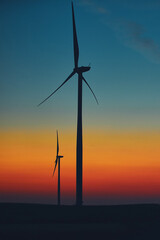 Windmill farm park in silhouettes with colorful sky.