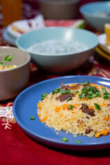 Uzbek pilaf with meat on a blue plate on the table
