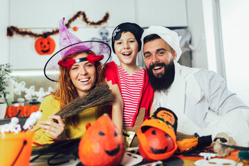 Happy family mother, father and son in costumes on a celebration of Halloween