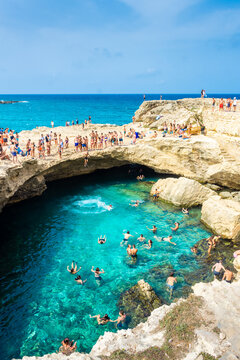 SALENTO, ITALY, 11 AUGUST 2021 People diving in the crystal clear water of the Grotta della Poesia (Poetry Cave)