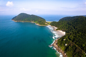 Imagem aérea da praia do Tombo, localizada na cidade do Guarujá. Ondas, natureza, montanhas e banhistas.
