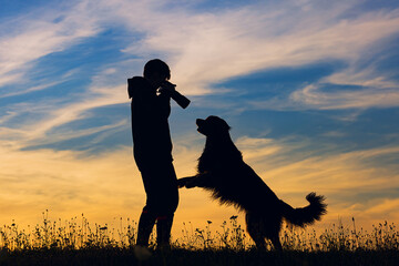 boy and hovie, two friends, silhouette of photographer and dog at sunset