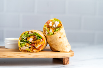 Fried chicken wrap on wood serving plate