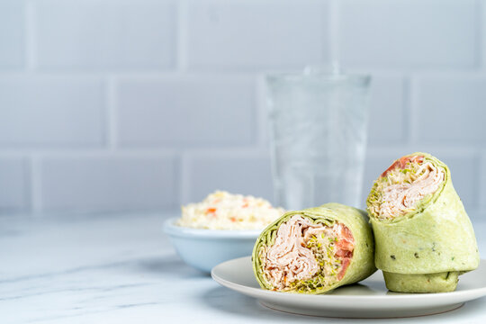 Turkey spinach wrap with coleslaw and a drink