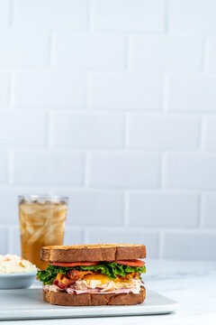 Deli sandwich with drink on light surface