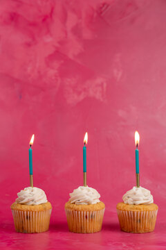Birthday cupcake with candles pink surface 