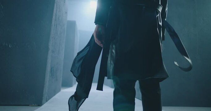 Rear back view of unknown man walking , standing or running inside dark maze. Dark corridor with concrete walls . Footage of mystical video. Shot on ARRI ALEXA Cinema Camera in slow motion  
