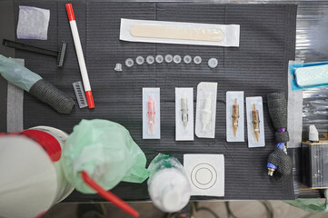 Tattoo studio scene. Set of different sterilized needles on the work table of a tattoo artist to...