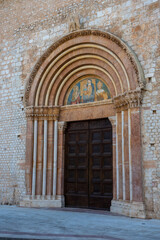 Fototapeta na wymiar Ornate side door of the rebuilt Romanesque basilica di Santa Maria di Collemaggio in L'Aquila, Italy