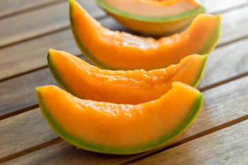 Fototapeta na wymiar Fresh juicy orange melon slices on wooden table close up