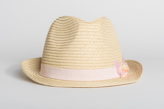 Womens summer straw hat with a pink ribbon on a white background.