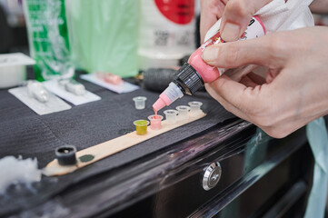 Tattoo studio scene. Pink ink refilling. Color palette on the work table of a tattoo artist to use...