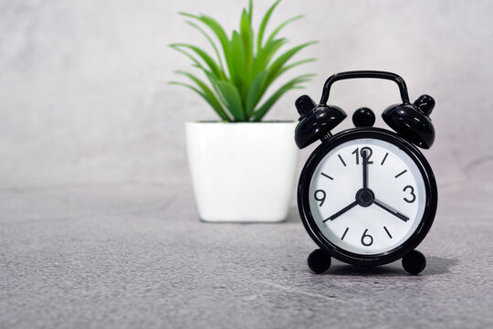 Black alarm clock isolated. The clock set at 8 o'clock. Deadline concept.