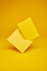 Yellow color paper office envelope with greeting, invitation or business card with copy space isolated on the bright solid fond plain yellow background
