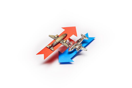 Two Toy Model Planes, Classic Vintage Small Passenger Airplanes Flying Into The Opposite Directions With Color Blue And Red Arrows Showing The Flight Levels Altitude Separation Difference