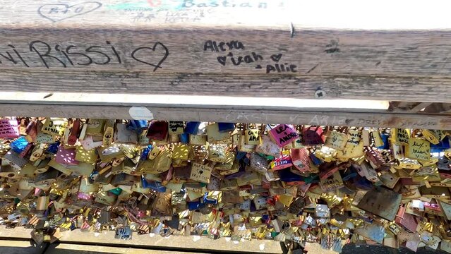 Valentines padlock on the bridge in Paris. Paris, France, 04 16 2022 Love padlocks on a bridge with a tourist boat out of focus, Seine river in Paris. France, Europe.