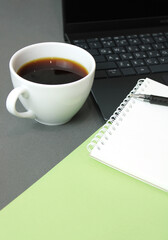 Modern workplace. Workplace with a laptop, diary, pen, coffee on a gray-green background. Freelance designer workplace