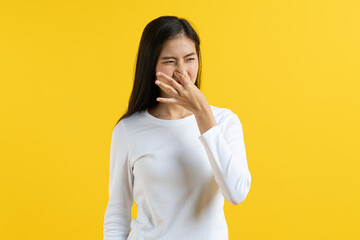 Expression of Asian young woman smelling bad stinky thing.