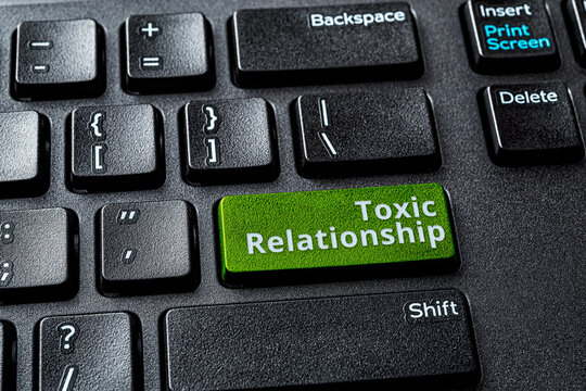 Toxic relationship words on the green enter key of a desktop computer keyboard. Concept of unsupported, misunderstood, demeaned relationship on the Internet. Destructive online communication.