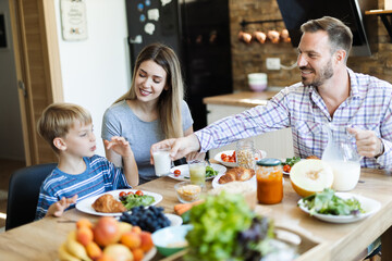  Young happy family enjoying in their breakfast time in dining room