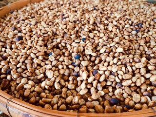 Fototapeta premium Coffee beans are waiting to be roasted. In a basket made of bamboo.