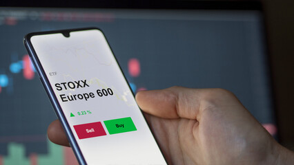 Un investisseur analyse un fonds etf stoxx europe 600 sur un graphique. Un téléphone affiche le cours de l'ETF STOXX Europe 600