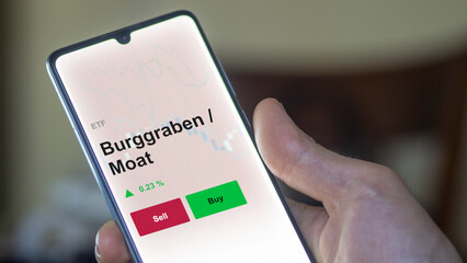 Un investisseur analyse un fonds etf burggraben / moat sur un graphique. Un téléphone affiche le cours de l'ETF Burggraben / Moat