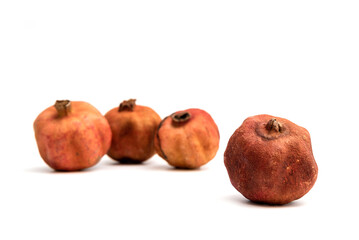Expired dried and spoiled pomegranates isolated on white background.