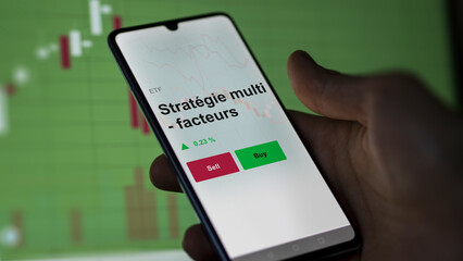 Un investisseur analyse un fonds etf stratégie multi - facteurs sur un graphique. Un téléphone affiche le cours de l'ETF Stratégie multi - facteurs