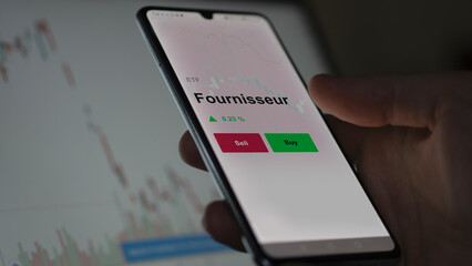Un investisseur analyse un fonds etf fournisseur sur un graphique. Un téléphone affiche le cours...