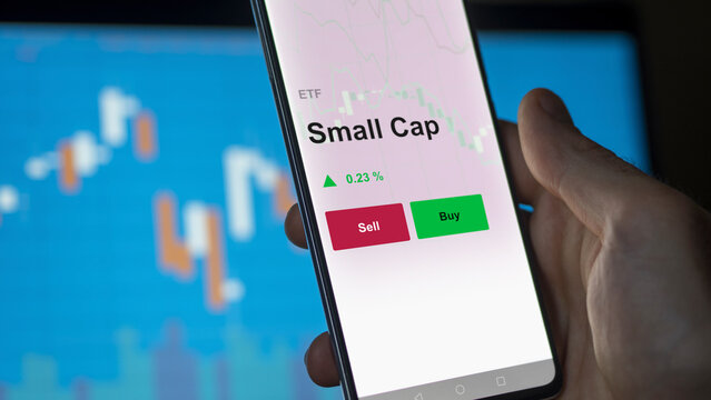 Un investisseur analyse un fonds etf small cap sur un graphique. Un t&eacute;l&eacute;phone affiche le cours de l'ETF Small Cap